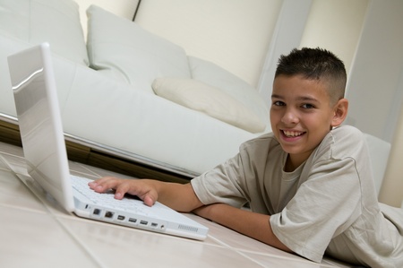 Boy Using Laptop on Living Room Floor