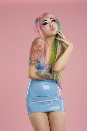 Young woman wearing party dress posing over pink backgroundの写真素材