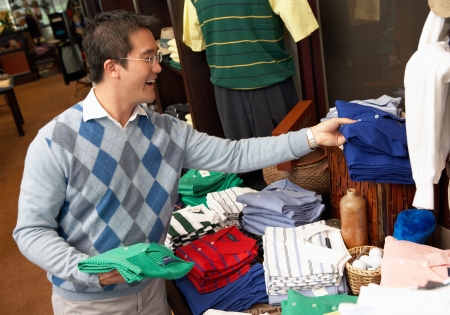 Mid-adult man looking at merchandise shopping in Golf Shopの写真素材