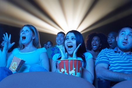 Young People screaming watching Horror Movie in Theatreの写真素材