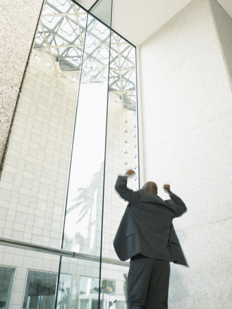 Businessman with arms raised in office buildingの写真素材