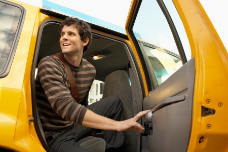 Man exiting taxi in street low angle view