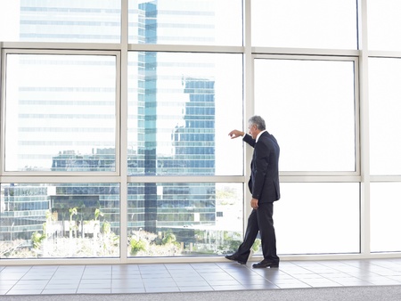 Businessman looking out of office windowの写真素材