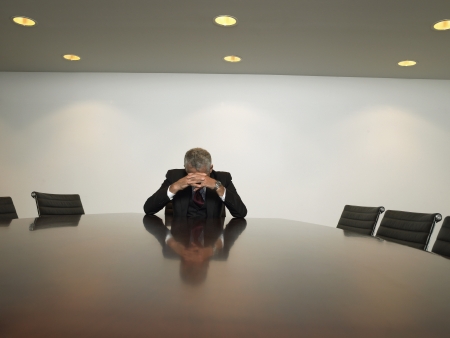 Stressed businessman in conference roomの写真素材