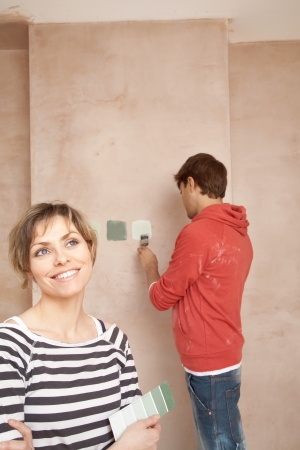 Couple choosing paint colours in unrenovated roomの写真素材