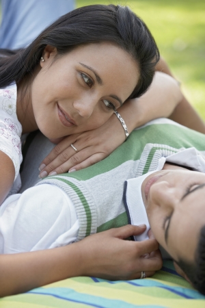 Couple lying down together on blanket in parkの写真素材