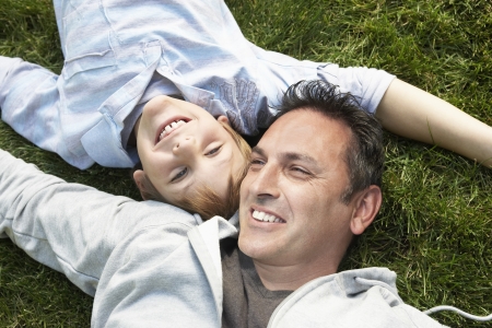 Father and Son Relaxing in the Grassの写真素材
