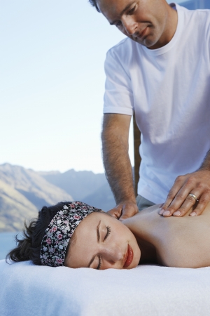 Woman getting a massage with mountains in backgroundの写真素材