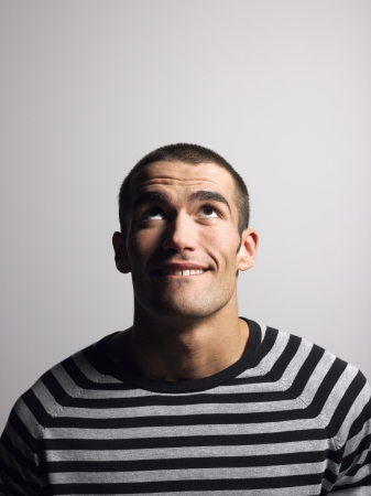 Man in striped shirt in studio looking up head and shouldersの写真素材