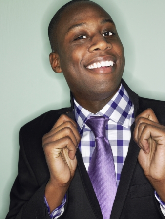 Businessman holding lapels in studio head and shouldersの写真素材