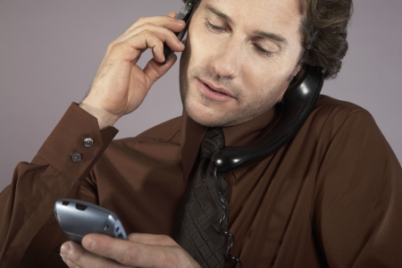 Multi-tasking Businessman Using Phonesの写真素材