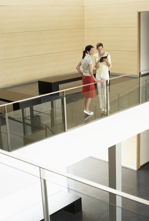 Businesswomen Conversing on Mezzanineの写真素材