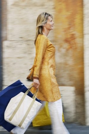Woman Walking with Shopping Bagsの写真素材