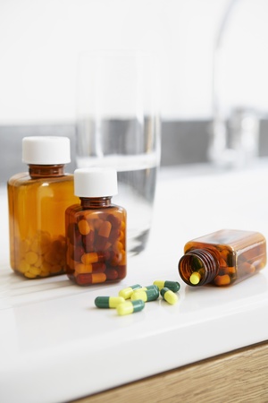 Spilt bottle of pills on counter in bathroom close upの写真素材