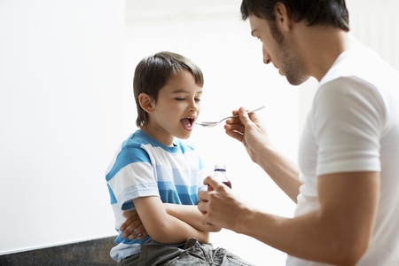 Father Giving Son Cough Syrupの写真素材