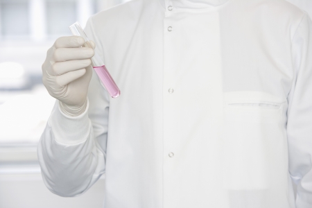 Scientist holding test tube sample, mid-sectionの写真素材