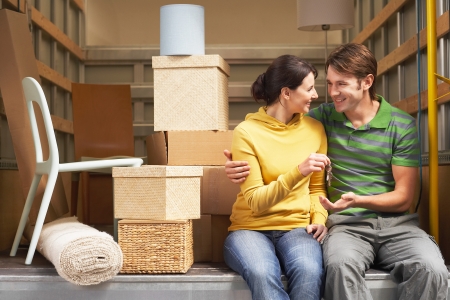 Couple Sitting in Back of Moving Van handing over keysの写真素材