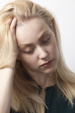Young woman suffering from headache against white backgroundの写真素材