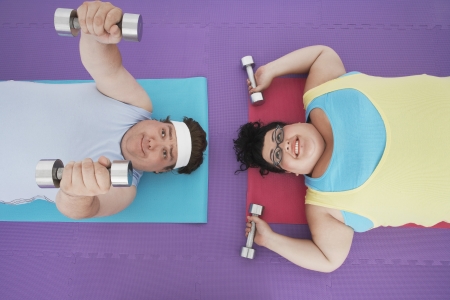 Overweight Couple Lifting Weightsの写真素材