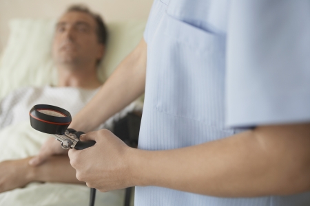 Nurse Taking Patient's Blood Pressure and Pulseの写真素材