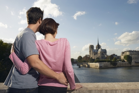 Paris France Couple embracing in front of Notre Dame Cathedral back viewの写真素材