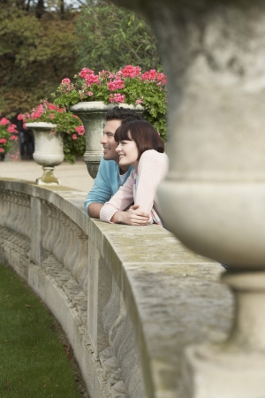 Couple looking over wall head and shouldersの写真素材