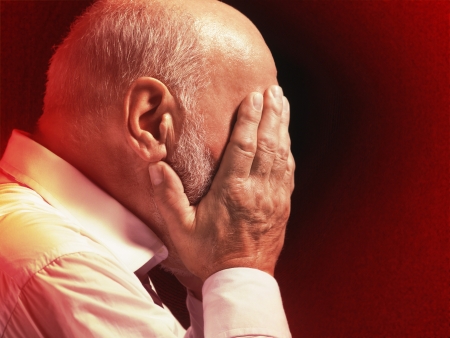 Middle Aged Businessman with head in hands profileの写真素材