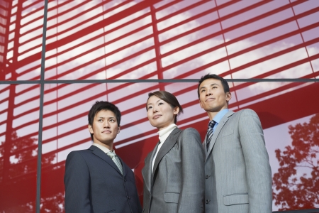 Businesspeople Standing outside beside red Building low angle viewの写真素材