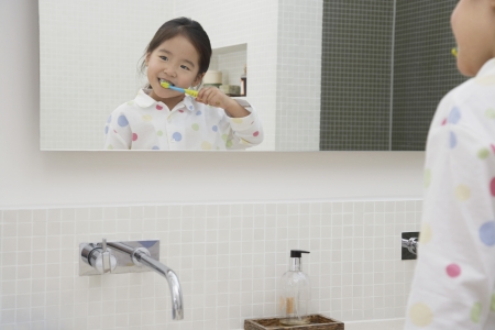 Reflection of Young Girl in pyjamas Brushing Her Teethの写真素材