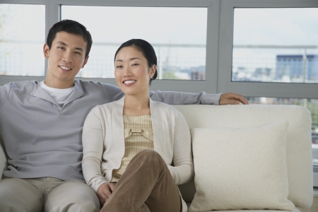 Husband Relaxing arm behind wife on Sofaの写真素材