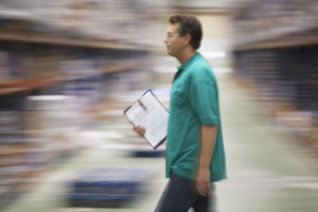 Warehouse Worker Carrying a Clipboard side viewの写真素材