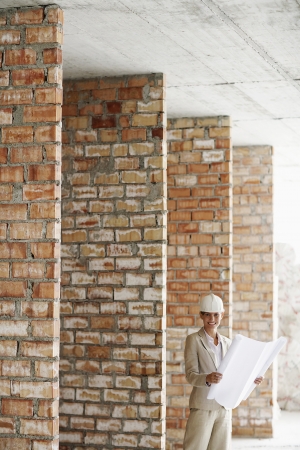 Architect holding plans at construction siteの写真素材
