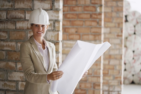 Architect holding plans at construction siteの写真素材