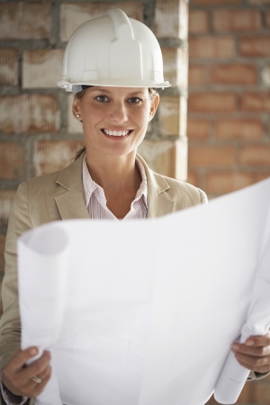 Architect holding plans at construction siteの写真素材