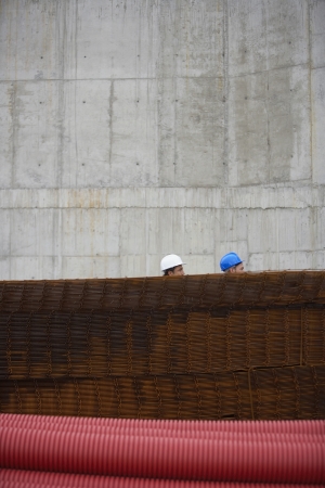 Two men at construction site behind stack of rebarの写真素材