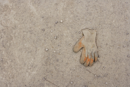Work glove lying in the dirtの写真素材