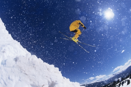 Skier in mid-air above snow on ski Slopesの写真素材