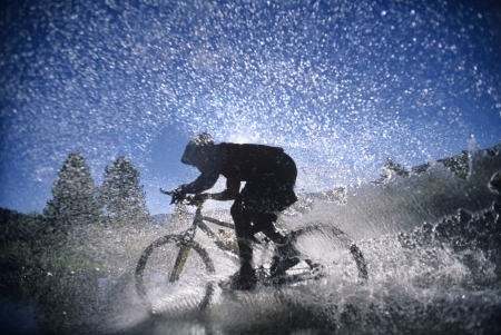 Mountain Bicyclist Splashing Through Water side viewの写真素材