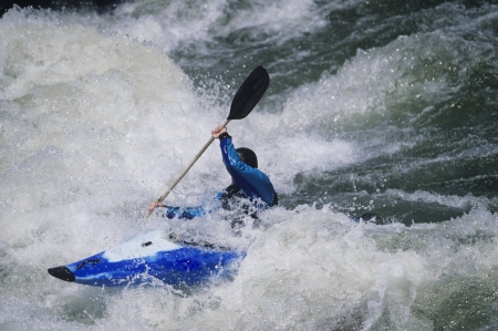 Kayaker paddling through white water Rapidsの写真素材