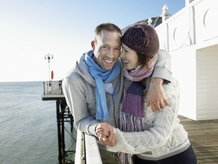 Couple holding hands standing on pier portraitの写真素材