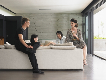 Young people drinking champagne in living roomの写真素材