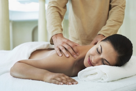 Young woman lying down and being massaged portraitの写真素材