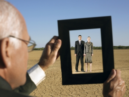 Businessman framing couple in desert