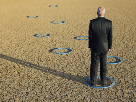 Businessman standing in hoops in desert back view full lengthの写真素材