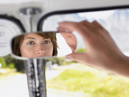 Woman Adjusting Rear view Mirror close up of hand focus on reflection in mirrorの写真素材