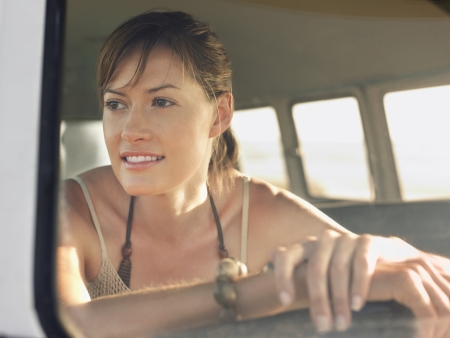 Woman in sitting in front seat of van head and shoulders view through window