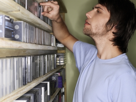 Young man browsing music collection side viewの写真素材