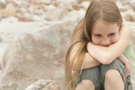 Pensive Girl on Rocky Beachの写真素材