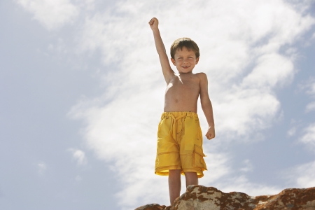 Boy on Rock Raising His Armの写真素材