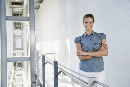 Businesswoman smiling in office building portraitの写真素材